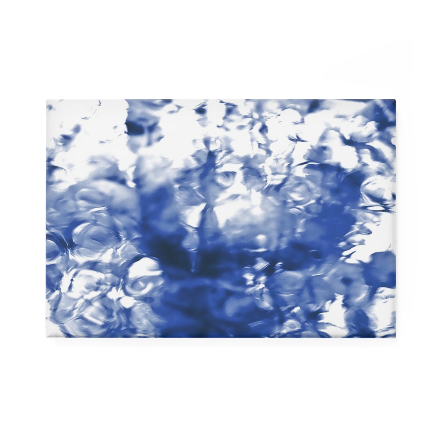 A rectangular button magnet with an image of a vivid blue water reflection design.