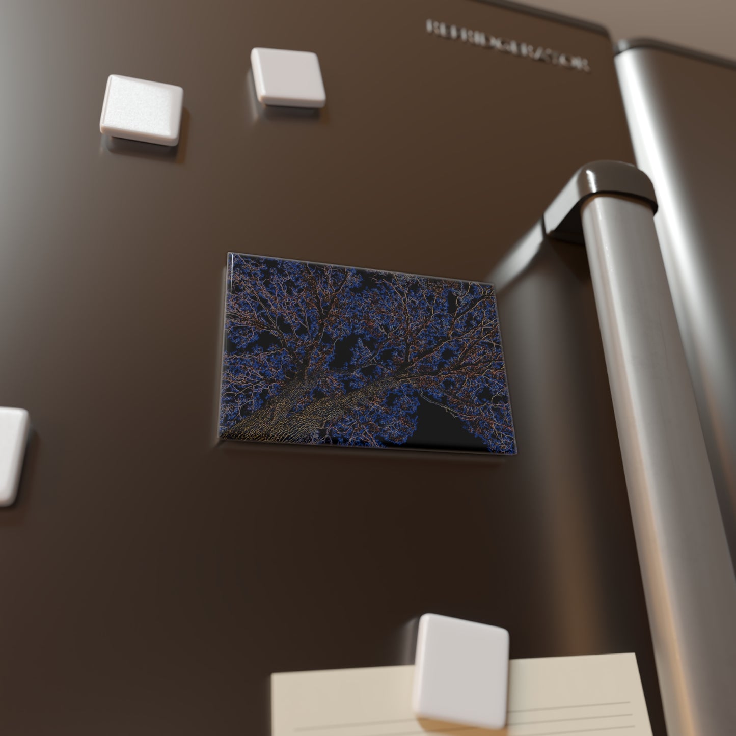 Lifestyle photo of a rectangular button magnet with an image of a neon blue and yellow tree design with lightning like features, placed on a fridge.