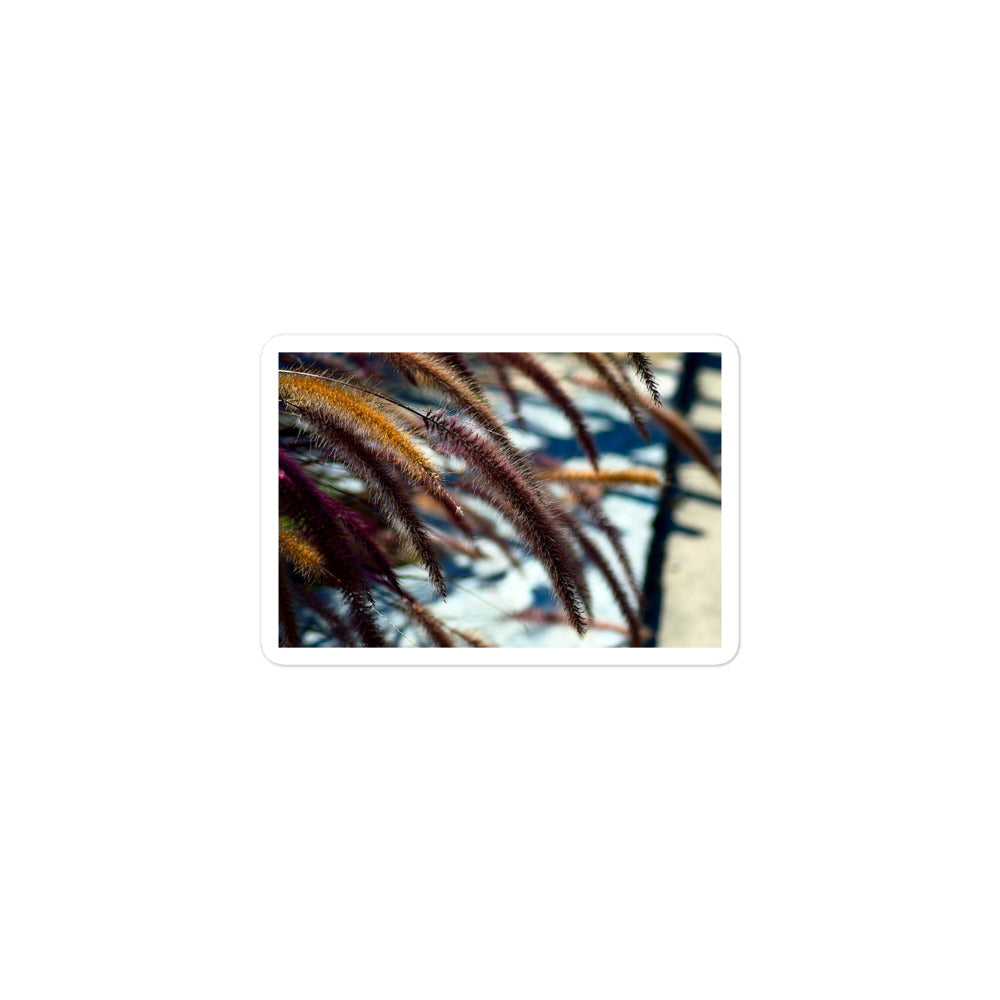 A small rectangular vinyl sticker with an image of yellow and purple foxtails.