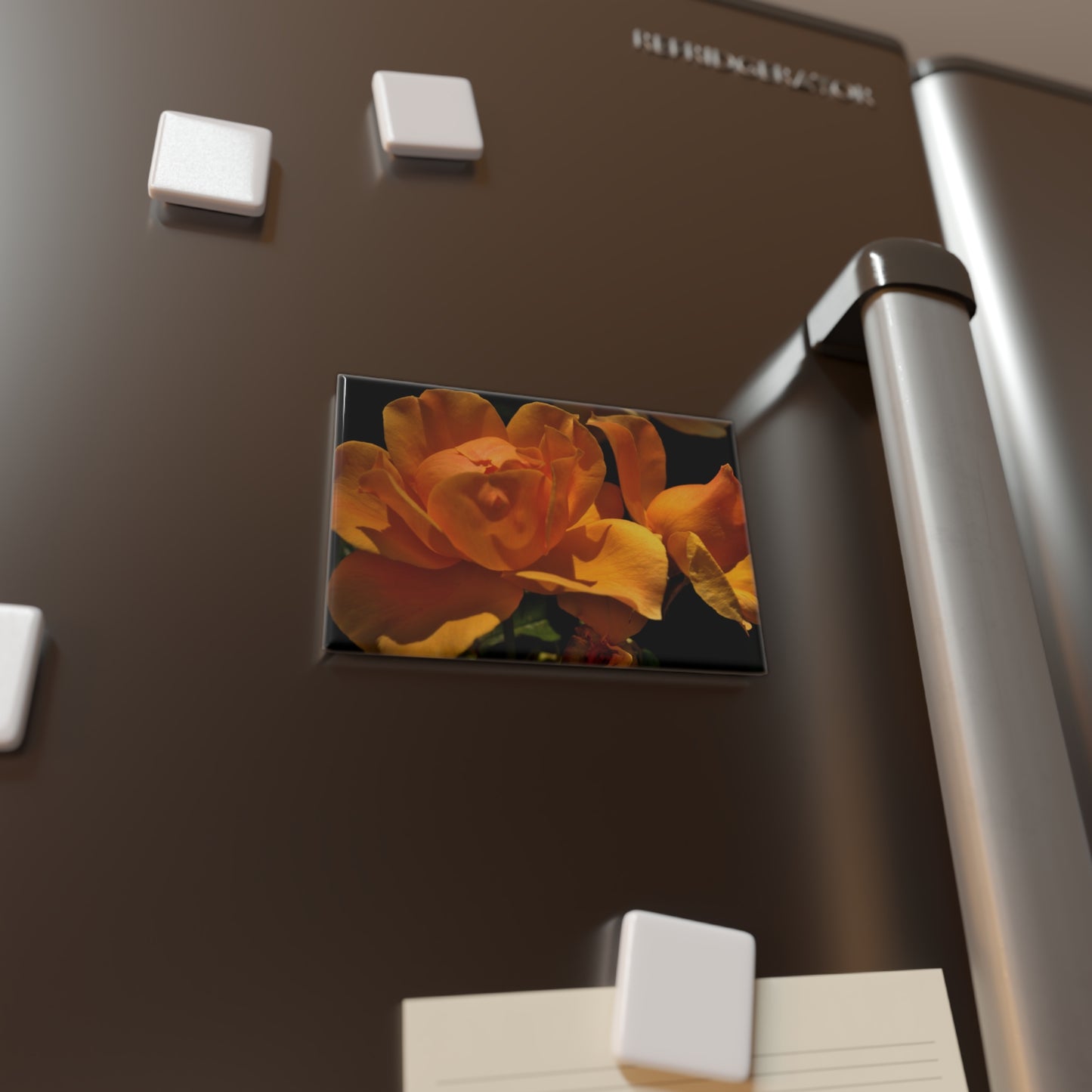 Lifestyle photo of a rectangular button magnet featuring a close-up image of a bold yellow rose, placed on a fridge.