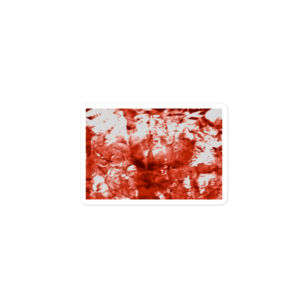 A small rectangular vinyl sticker with an image of a vivid red water reflection design.
