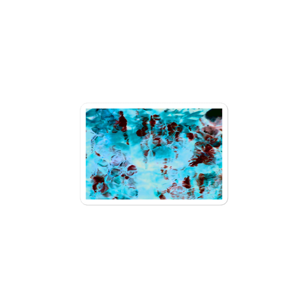 A small rectangular vinyl sticker with an image of a vivid blue and red water reflection design.