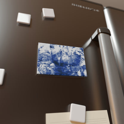 Lifestyle photo of a rectangular button magnet with an image of a vivid blue water reflection design, placed on a fridge.