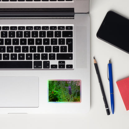 Lifestyle photo of a rectangular holographic sticker with an image of a purple lavender bloom in an herb garden, placed on a laptop to the right of the mouse pad.