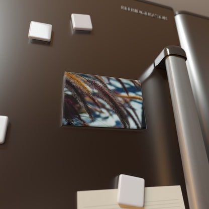 Lifestyle photo of a rectangular button magnet with an image of golden and purple foxtails against a blurred gray background, placed on a fridge.