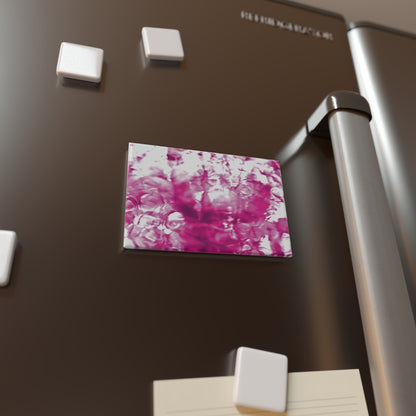 Lifestyle photo of a rectangular button magnet with an image of a vivid pink water reflection design, placed on a fridge.